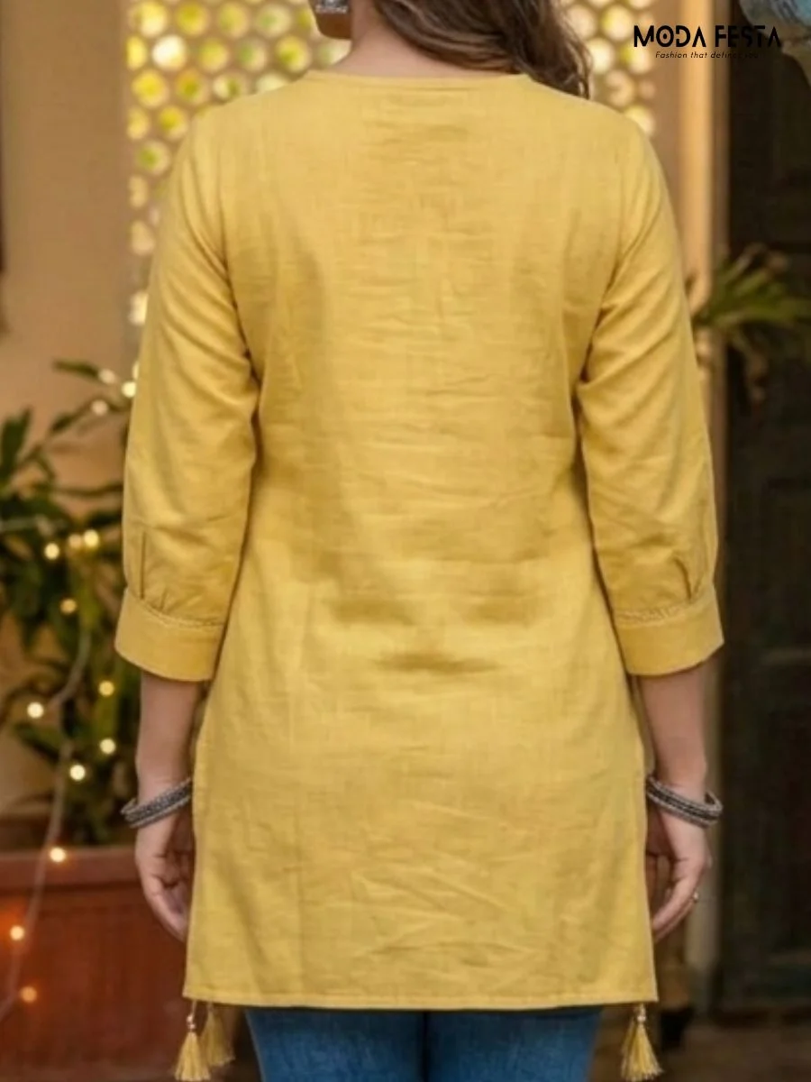This vibrant mustard yellow kurti features a delicate floral motif and tassel detail, offering a perfect blend of understated elegance and ethnic style.