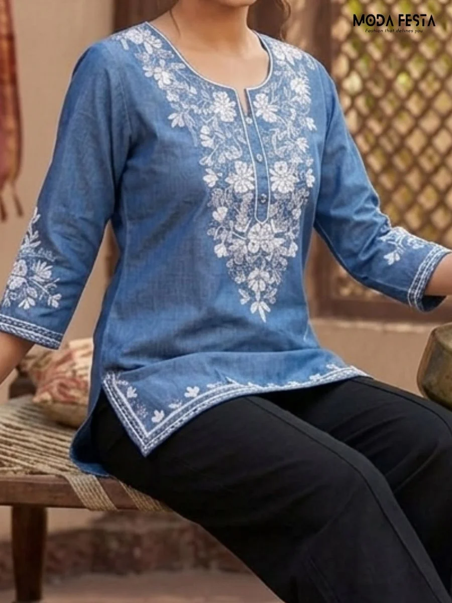 This stylish blue denim short kurti features intricate white embroidery and convenient front pockets, offering a perfect blend of comfort and ethnic charm for any casual occasion.