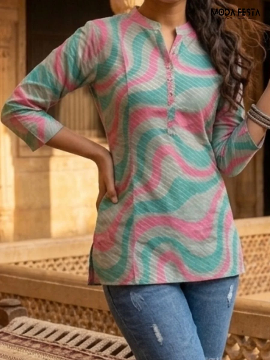 This vibrant short kurti features a modern wavy print in teal and pink, accented with subtle metallic shimmer and a classic mandarin collar.