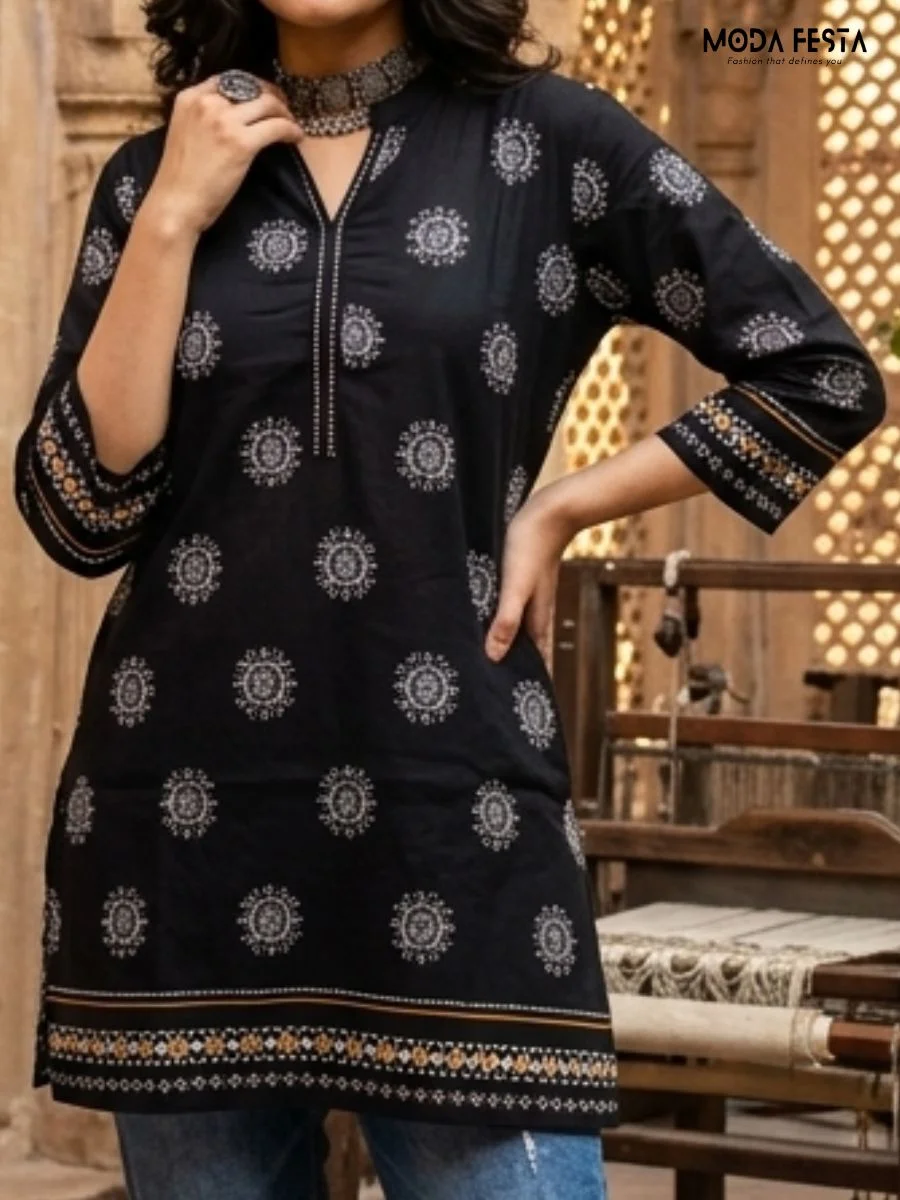 This striking black kurti features a sophisticated mandala-inspired circular print, perfectly complemented by a detailed contrast border and a refined, elegant neckline.