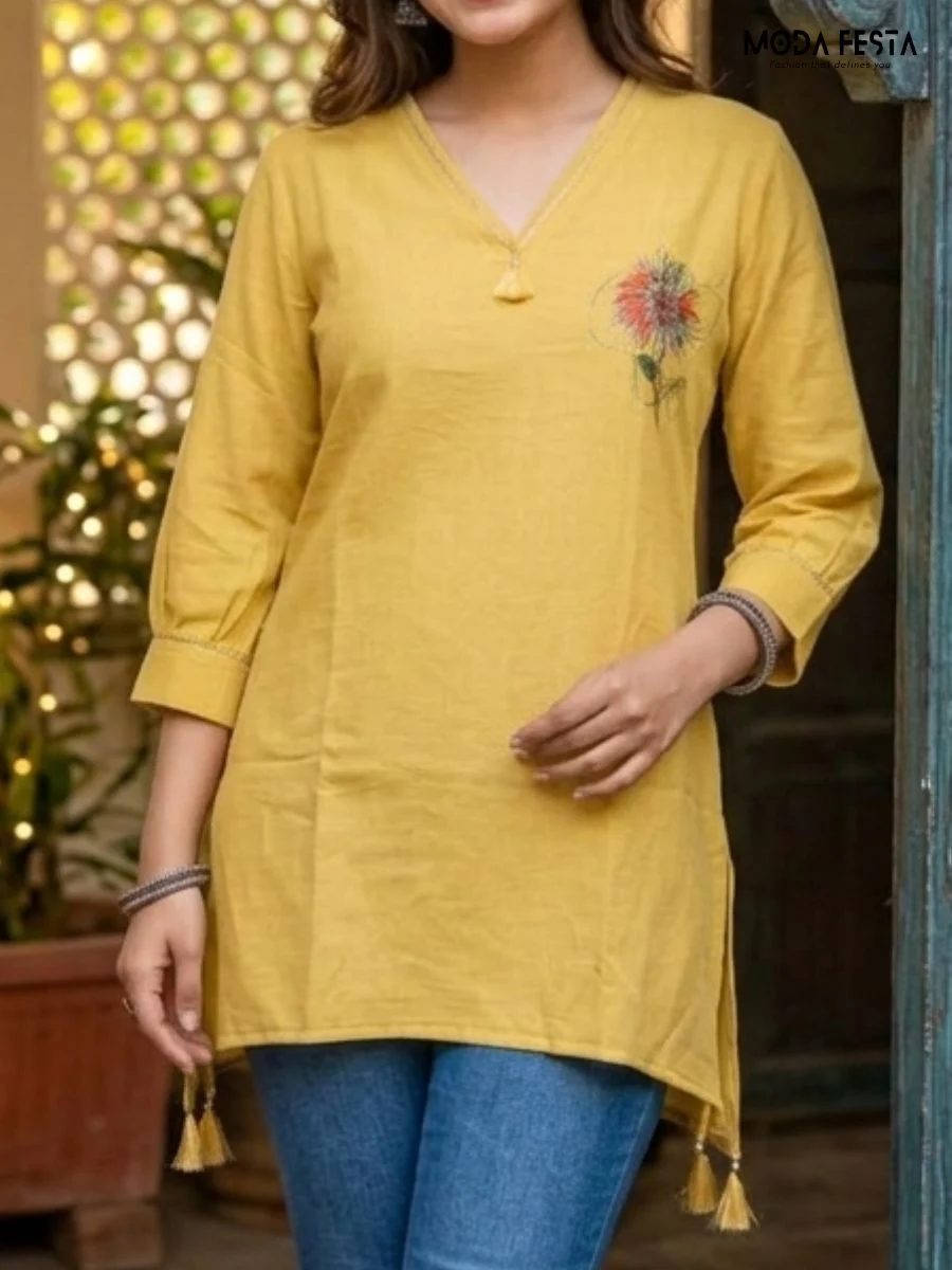This vibrant mustard yellow kurti features a delicate floral motif and tassel detail, offering a perfect blend of understated elegance and ethnic style.