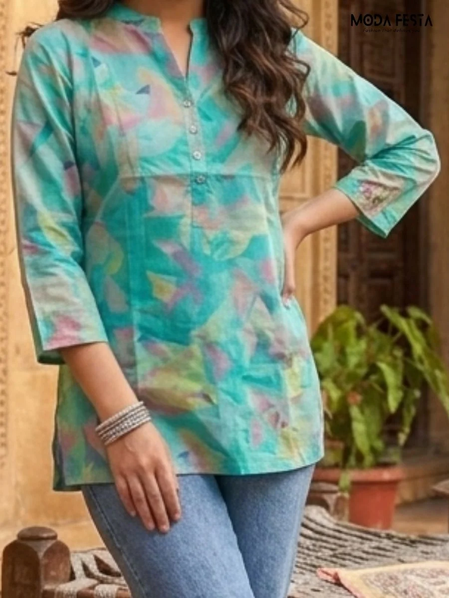 This refreshing short kurti features a soft, watercolor-inspired abstract print in vibrant teal tones, finished with a classic button-down mandarin collar.