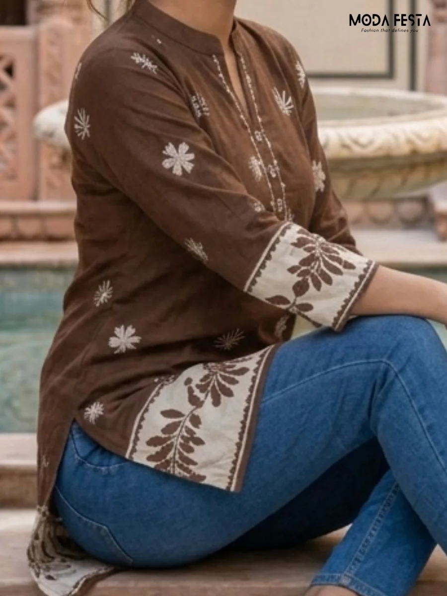 This earthy brown short kurti features a charming contrast white border and delicate floral motifs, elegantly finished with a classic mandarin collar.