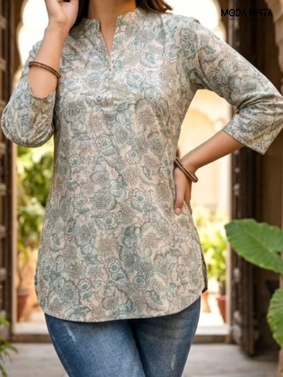 This elegant sage-toned tunic features a delicate, all-over botanical print that offers a sophisticated and timeless look for your everyday collection.