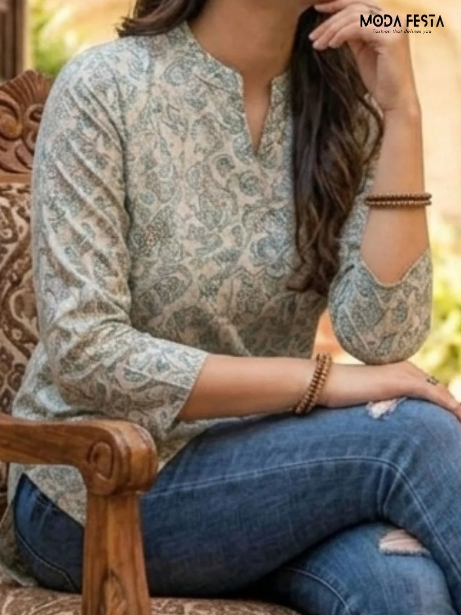 This elegant sage-toned tunic features a delicate, all-over botanical print that offers a sophisticated and timeless look for your everyday collection.
