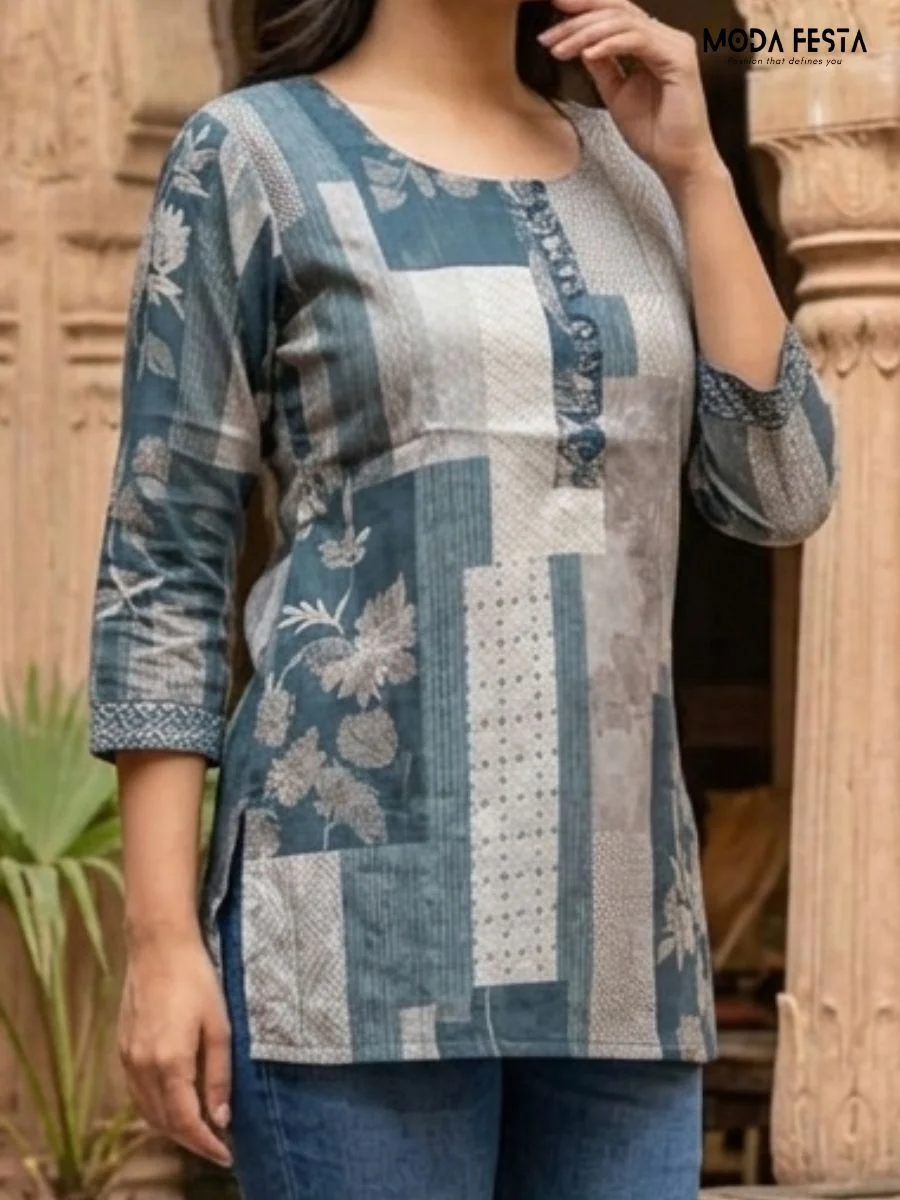 This stylish blue kurti features a unique patchwork-inspired print that blends floral and geometric patterns for a modern take on traditional ethnic wear.