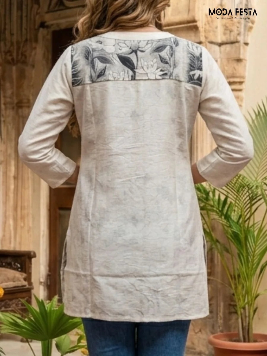 This elegant, off-white kurti features a sophisticated charcoal floral print and a sleek button-down placket, creating a versatile piece for effortless everyday styling.