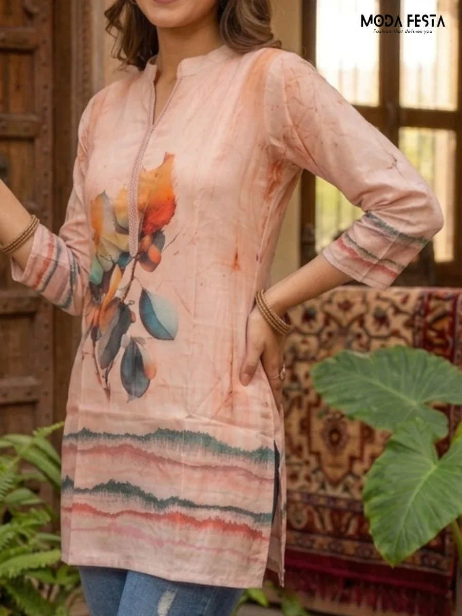 This artistic tunic showcases a vibrant, watercolor-inspired leaf motif on a soft peach background, offering a creative and contemporary take on traditional ethnic wear.