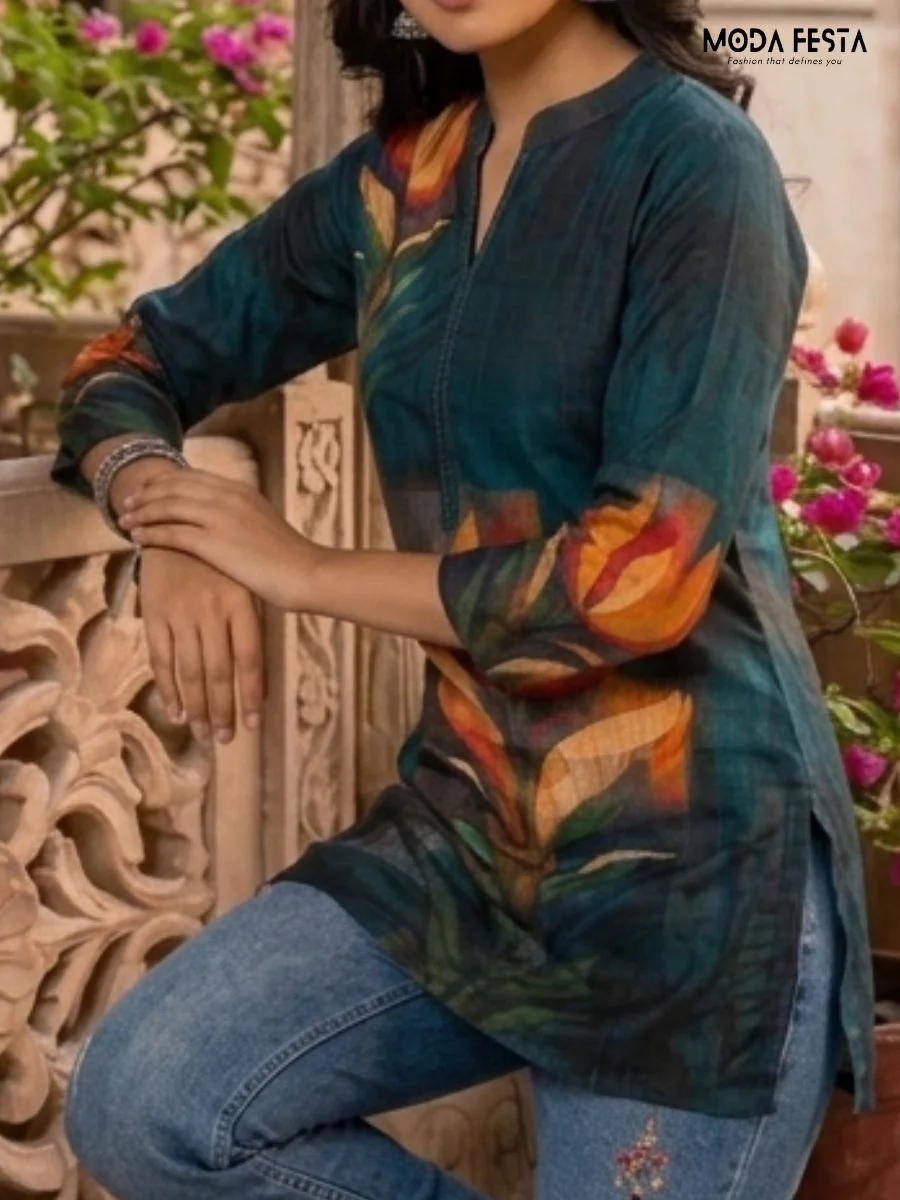 This striking teal short kurti features a bold, artistic floral print and a sleek band neckline, offering a modern and sophisticated take on ethnic casual wear.