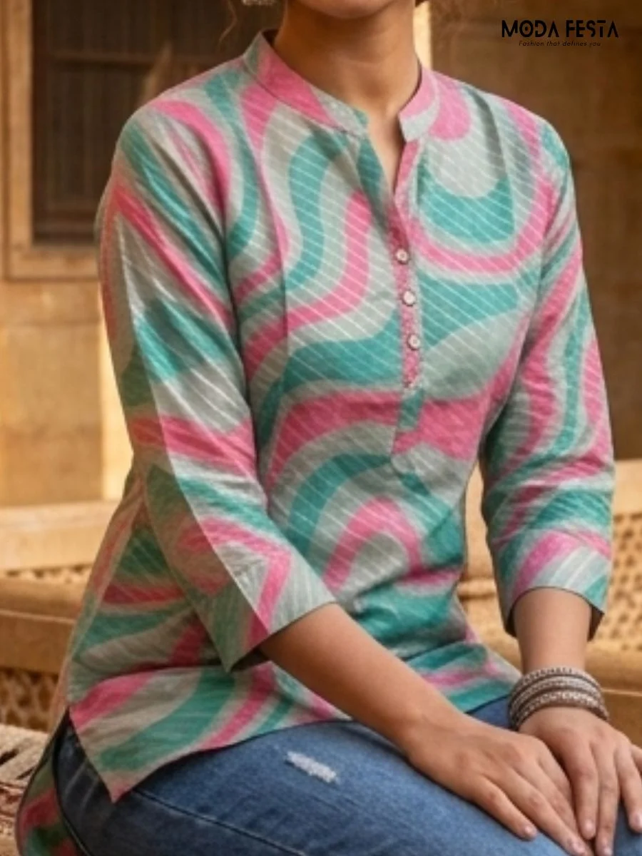 This vibrant short kurti features a modern wavy print in teal and pink, accented with subtle metallic shimmer and a classic mandarin collar.